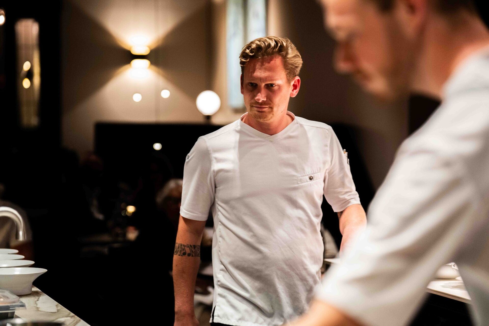 Twee chefs van Ode overleggen in de open keuken